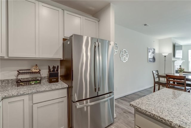 12106 Oxford Landing Dr Unit 202, Glen Allen, VA 23059 - kitchen with freestanding refrigerator, light wood-style floors, white cabinets, and light stone countertops
