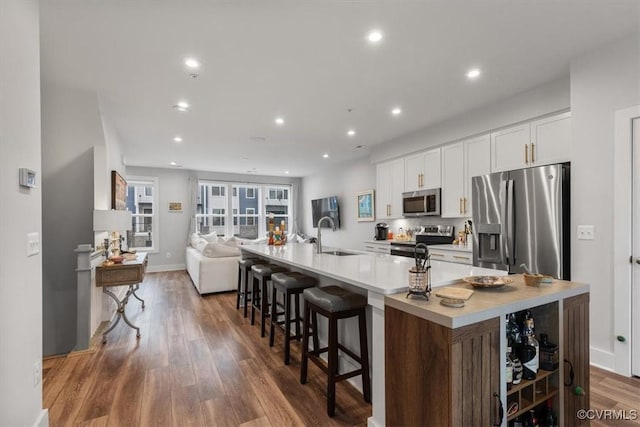 5234 Old Main St Unit C, Henrico, VA 23231 - kitchen with stainless steel appliances, white cabinets, a large island with sink, wood finished floors, and light countertops