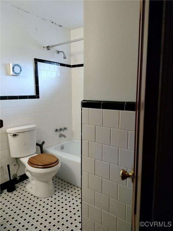 724 Milton Dr, Hampton, VA 23666 - bathroom with tile walls, toilet, tile patterned flooring, tub / shower combination, and a wainscoted wall