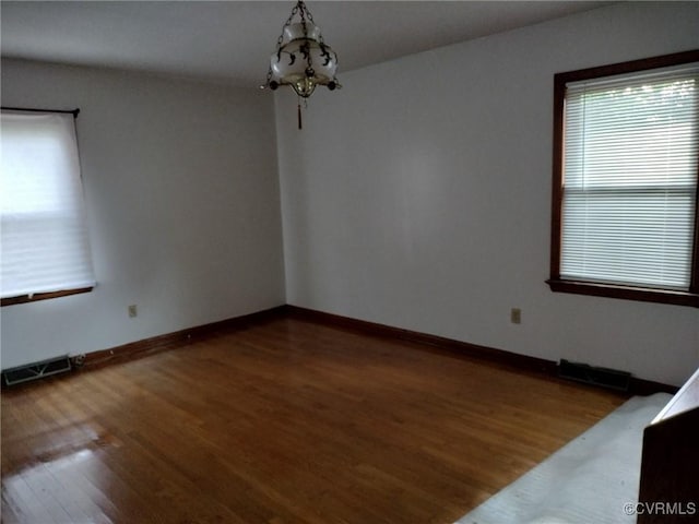 724 Milton Dr, Hampton, VA 23666 - spare room featuring healthy amount of natural light, a chandelier, wood finished floors, and baseboards