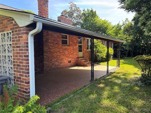 724 Milton Dr, Hampton, VA 23666 - view of side of home featuring a chimney, a yard, entry steps, brick siding, and a patio