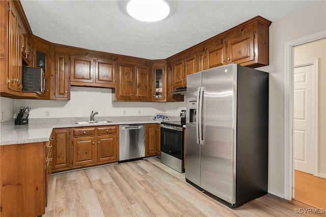 9865 Knobs Hill Ln, Amelia, VA 23002 - kitchen featuring stainless steel appliances, ventilation hood, light wood finished floors, brown cabinets, and glass insert cabinets