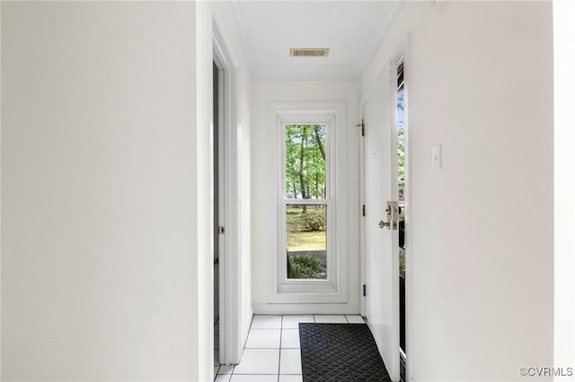 doorway to outside with crown molding and light tile patterned floors
