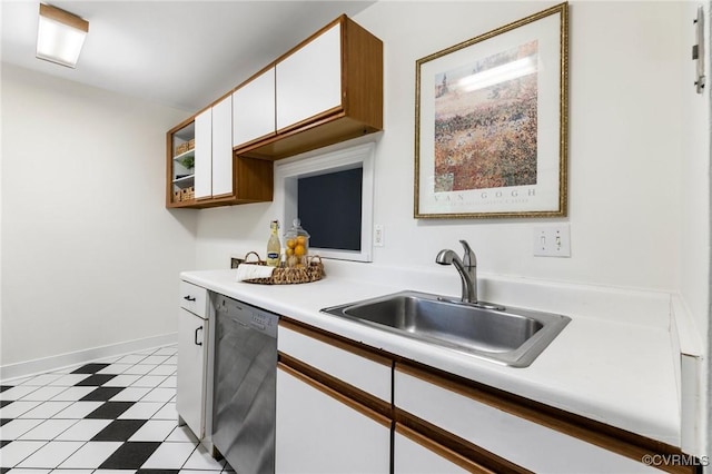 kitchen with dishwasher, white cabinetry, a sink, light countertops, and light flooring