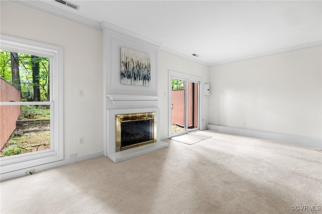 unfurnished living room with a glass covered fireplace, crown molding, carpet flooring, and baseboards
