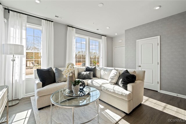 living area with healthy amount of natural light, light wood-type flooring, baseboards, and recessed lighting