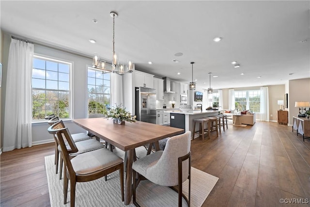 dining space featuring dark wood-type flooring, recessed lighting, baseboards, and a chandelier
