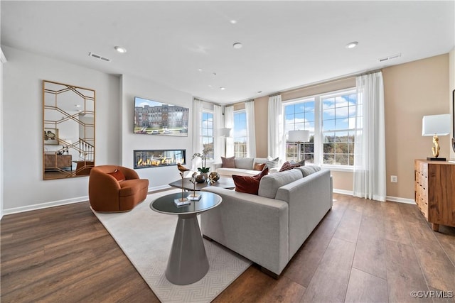 living room featuring wood finished floors, baseboards, and recessed lighting