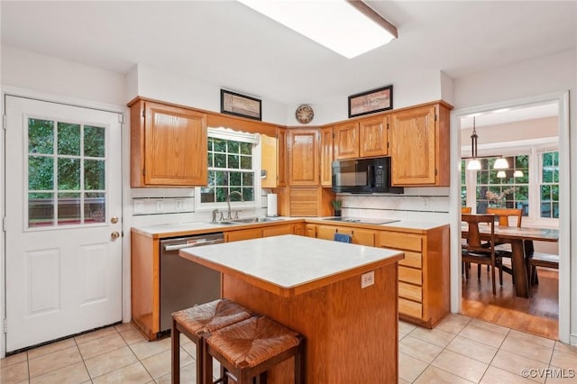 kitchen with black appliances, a sink, light tile patterned floors, and light countertops