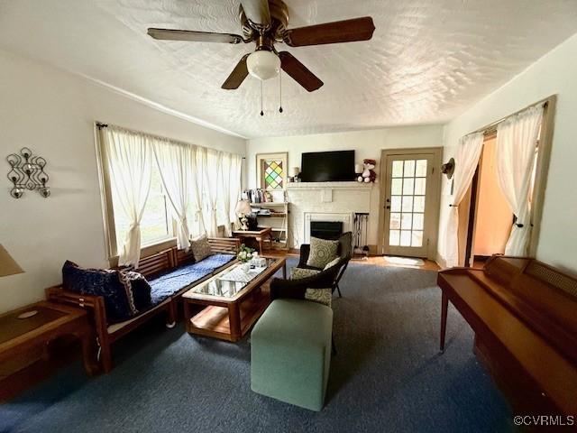 111 Jefferson St, Emporia, VA 23847 - carpeted living room featuring a fireplace, a textured ceiling, and ceiling fan