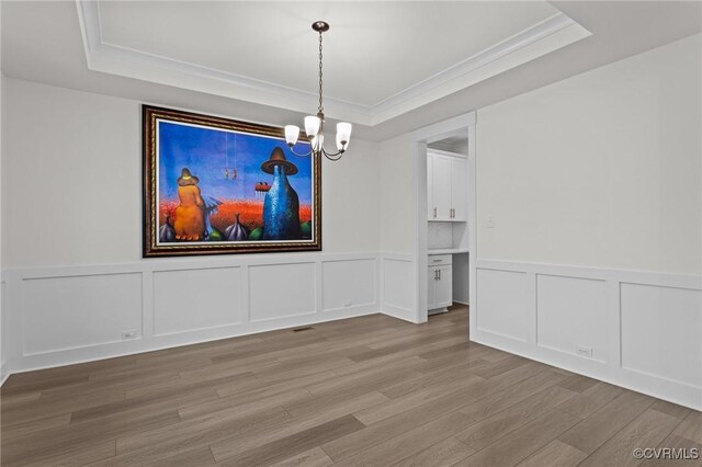 9975 Honeybee Dr, Mechanicsville, VA 23116 - unfurnished dining area featuring a tray ceiling, a chandelier, a decorative wall, light wood finished floors, and ornamental molding