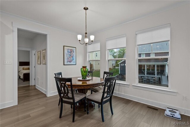 9975 Honeybee Dr, Mechanicsville, VA 23116 - dining area featuring wood finished floors, crown molding, a chandelier, and baseboards