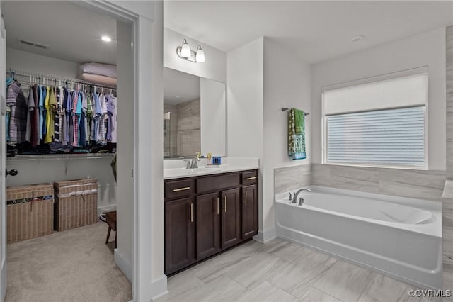 9975 Honeybee Dr, Mechanicsville, VA 23116 - full bath with vanity, a garden tub, and a walk in closet