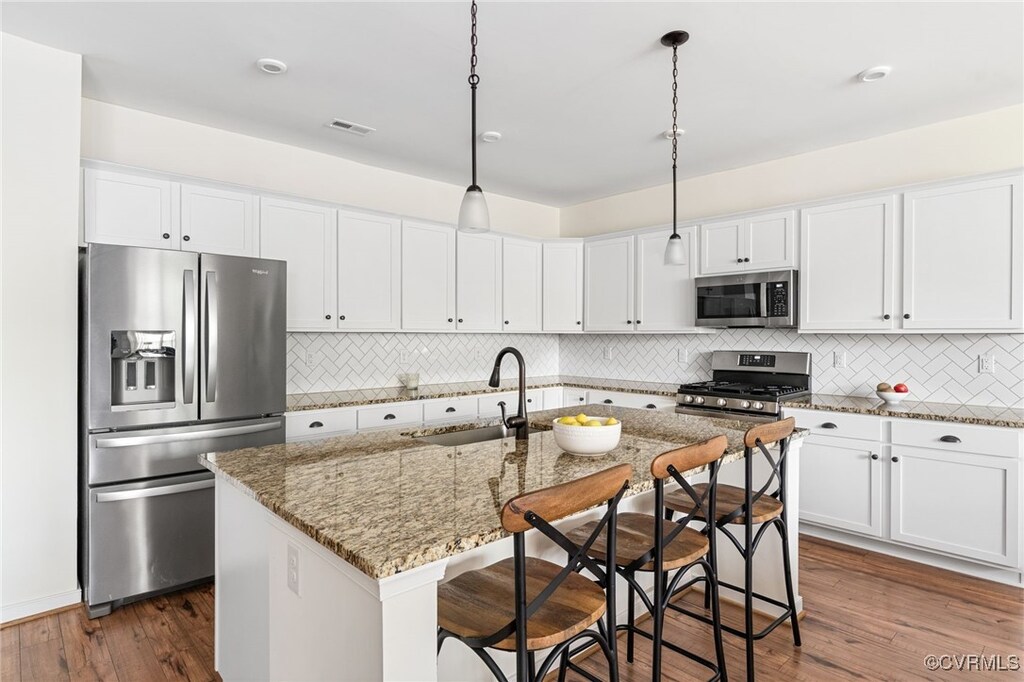 6604 Way Point Dr, Chesterfield, VA 23234 - kitchen featuring stainless steel appliances, a sink, white cabinets, decorative backsplash, and dark wood finished floors