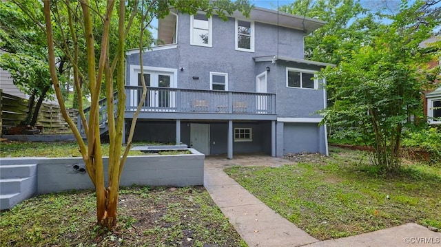 rear view of house with a wooden deck and stucco siding