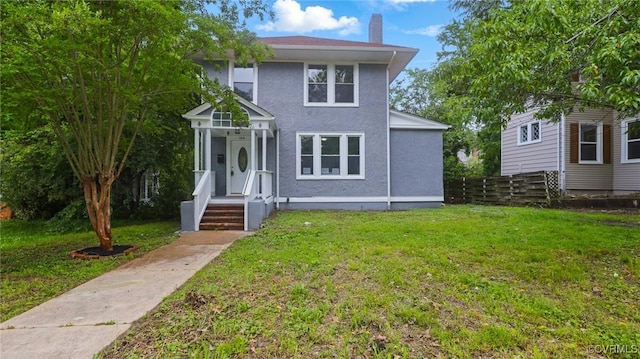 american foursquare style home with a chimney and stucco siding