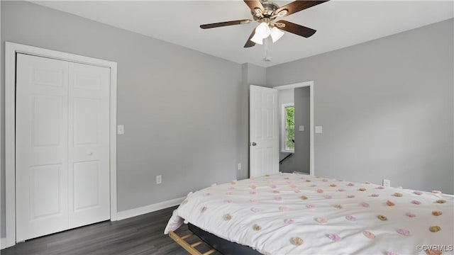 bedroom with dark wood-type flooring, a closet, baseboards, and ceiling fan