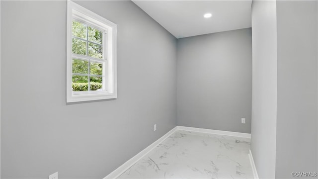 unfurnished room featuring marble look tile flooring, baseboards, and recessed lighting