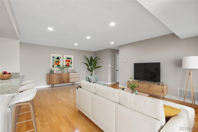 living area with recessed lighting, light wood-style flooring, and baseboards
