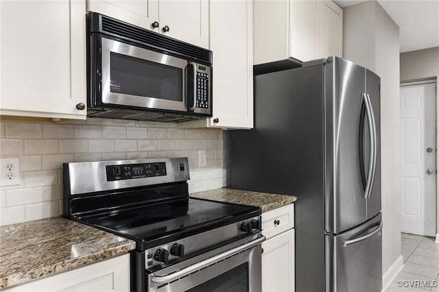 kitchen featuring stainless steel appliances, decorative backsplash, stone counters, and white cabinetry