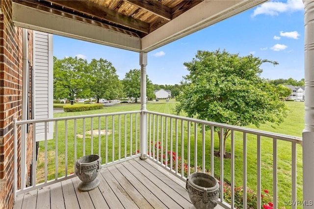 wooden terrace featuring a yard
