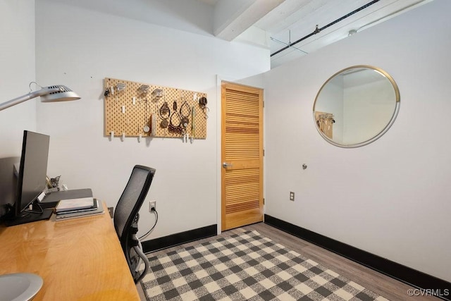 office space with wood finished floors, baseboards, and beam ceiling
