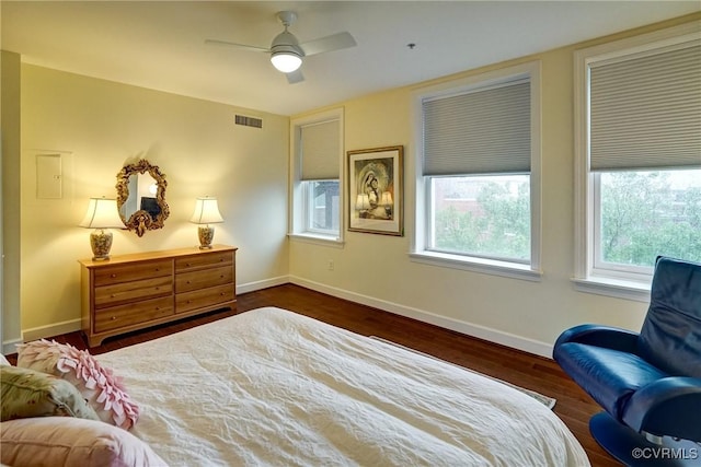 bedroom with dark wood-type flooring, multiple windows, and baseboards