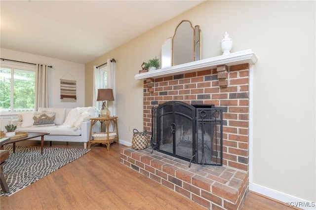 9830 Knobs Hill Ln, Amelia Courthouse, VA 23002 - living room featuring wood finished floors, a brick fireplace, and baseboards