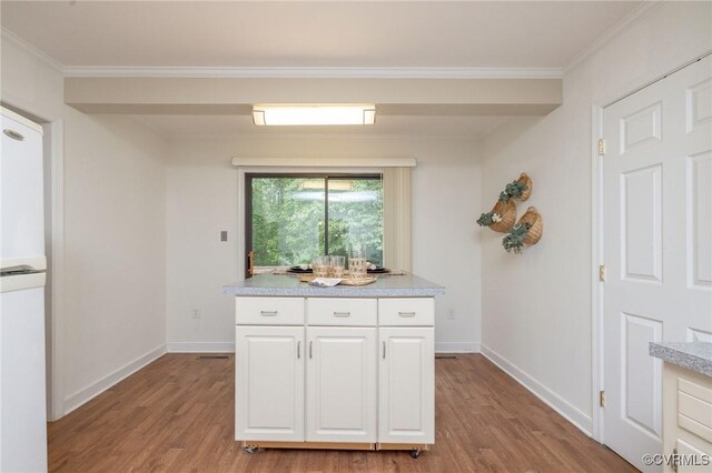 9830 Knobs Hill Ln, Amelia Courthouse, VA 23002 - kitchen with wood finished floors, light countertops, white cabinetry, baseboards, and crown molding