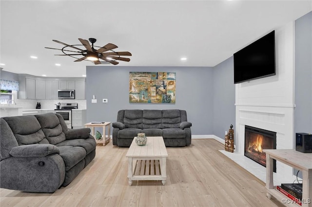 686 Shore Dr, Hartfield, VA 23071 - living area featuring light wood-style floors, a ceiling fan, a fireplace with flush hearth, recessed lighting, and baseboards