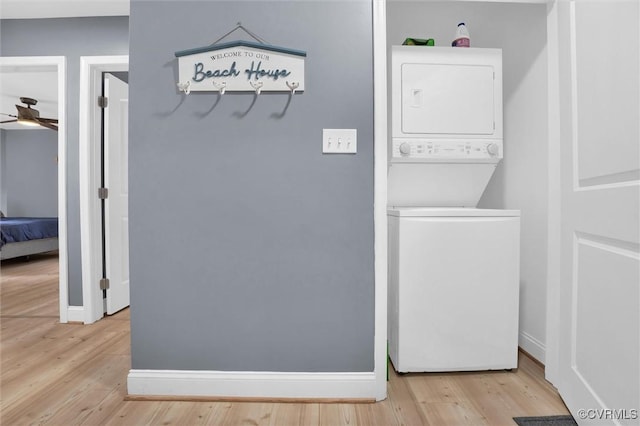 686 Shore Dr, Hartfield, VA 23071 - washroom featuring stacked washer / dryer, a ceiling fan, wood finished floors, and baseboards