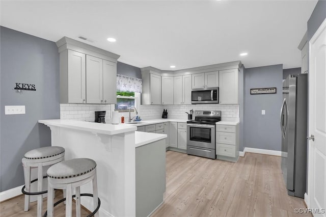 686 Shore Dr, Hartfield, VA 23071 - kitchen with stainless steel appliances, a peninsula, a sink, backsplash, and a kitchen breakfast bar