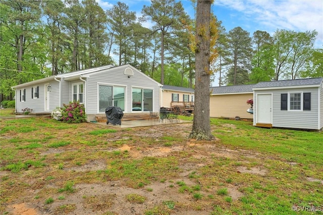 686 Shore Dr, Hartfield, VA 23071 - back of house with an outdoor structure, a patio, and a yard