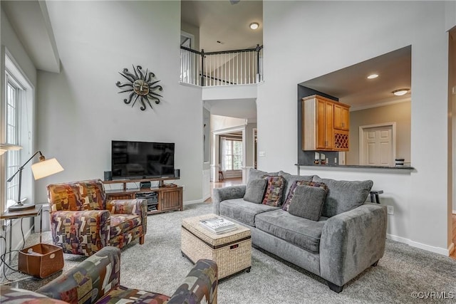 living room with carpet floors, baseboards, a towering ceiling, and recessed lighting