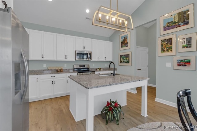 926 Old Saint Johns Rd, Irvington, VA 22480 - kitchen featuring appliances with stainless steel finishes, a sink, vaulted ceiling, light wood finished floors, and light stone countertops