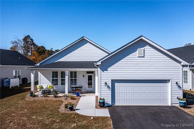 926 Old Saint Johns Rd, Irvington, VA 22480 - view of front facade with asphalt driveway, an attached garage, covered porch, and a front yard