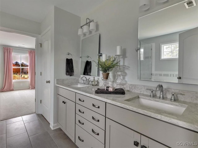 bathroom with an enclosed shower, double vanity, and tile patterned flooring