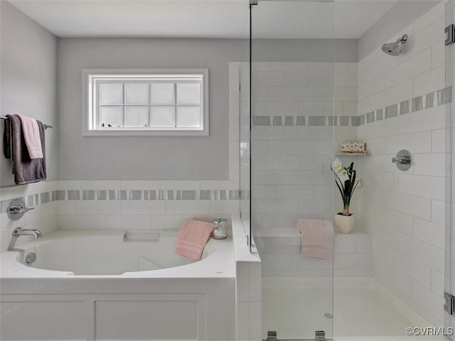 bathroom with a stall shower and a garden tub
