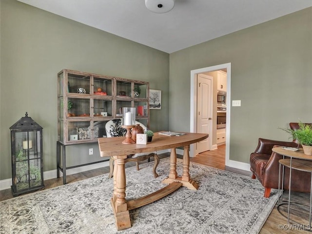 office area with baseboards and wood finished floors