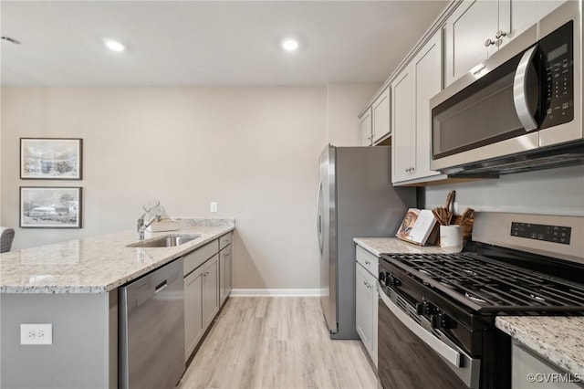 5916 Banyan Ln, Chesterfield, VA 23234 - kitchen featuring appliances with stainless steel finishes, a sink, a peninsula, light wood finished floors, and light stone counters