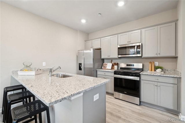 5916 Banyan Ln, Chesterfield, VA 23234 - kitchen with stainless steel appliances, a sink, a peninsula, light wood-type flooring, and gray cabinetry