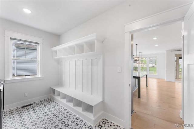 mudroom featuring baseboards, recessed lighting, and light floors
