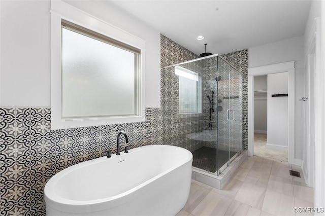 bathroom with a shower stall, a freestanding tub, a walk in closet, and recessed lighting