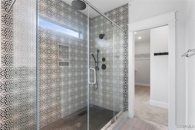 bathroom featuring a stall shower and a spacious closet
