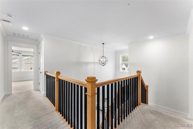 hallway featuring an upstairs landing, crown molding, carpet floors, baseboards, and recessed lighting