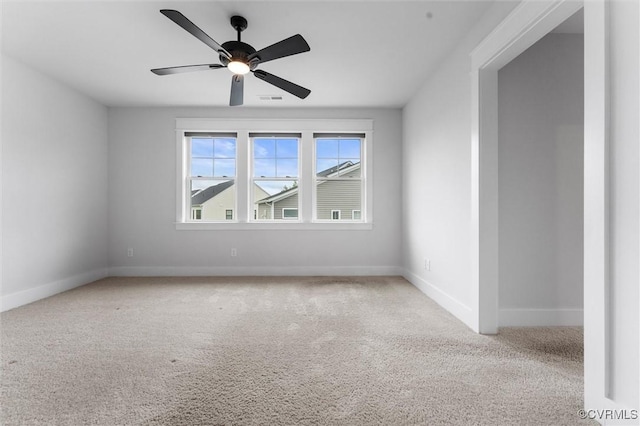 unfurnished room featuring carpet floors, baseboards, and a ceiling fan