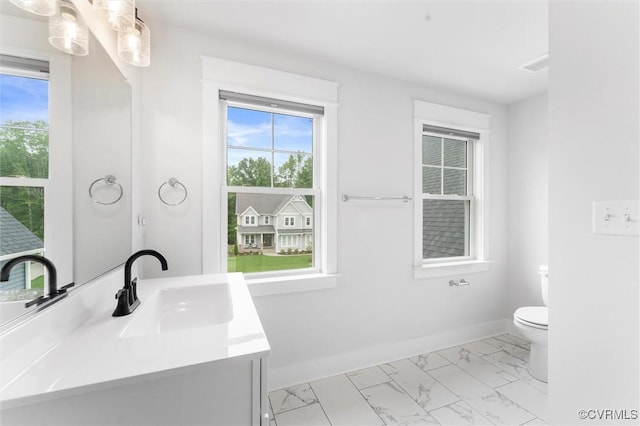 bathroom with marble look tiles, toilet, vanity, and baseboards