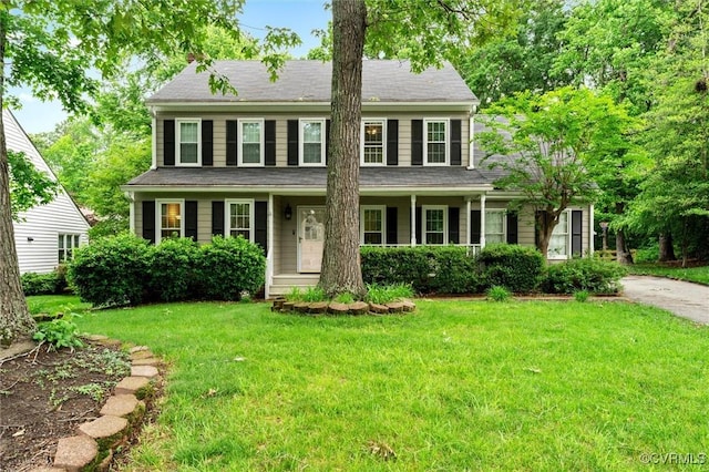 colonial-style house with a front yard and covered porch