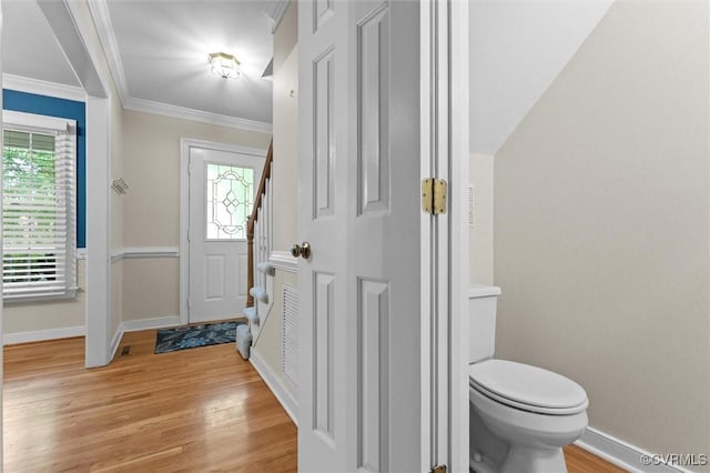 foyer featuring light wood-type flooring, baseboards, plenty of natural light, and ornamental molding