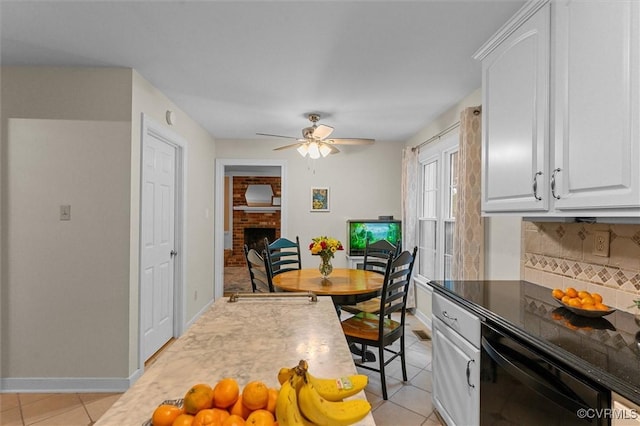 kitchen with dishwasher, light tile patterned flooring, a fireplace, decorative backsplash, and a ceiling fan